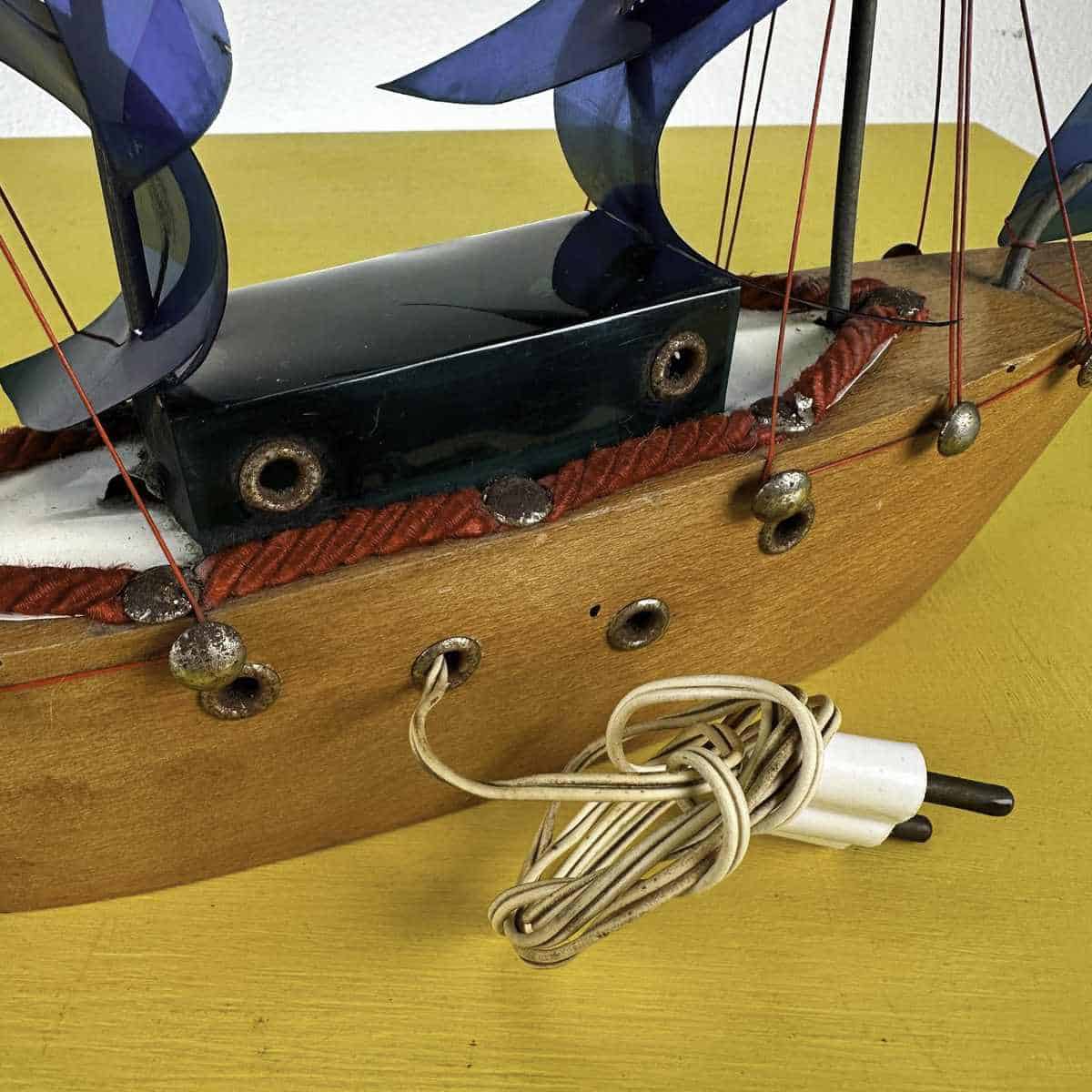 Una nave accesa sullo scaffale: storia e linguaggio del modellino di veliero 2 Dettaglio laterale di veliero artigianale vintage con lucina interna