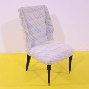 Poltroncina in tessuto fantasia chiara con gambe in legno e puntali