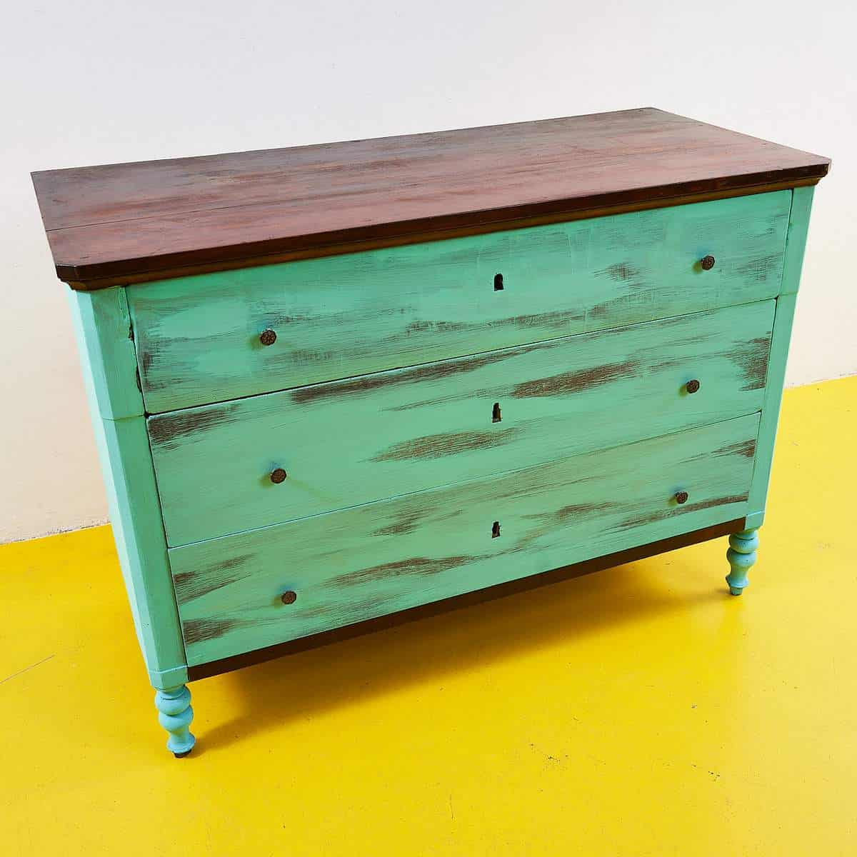Tre cassetti, una tinta fresca: la cassettiera verde menta tra funzione e carattere 1 Cassettiera verde menta con tre cassetti e piano scuro